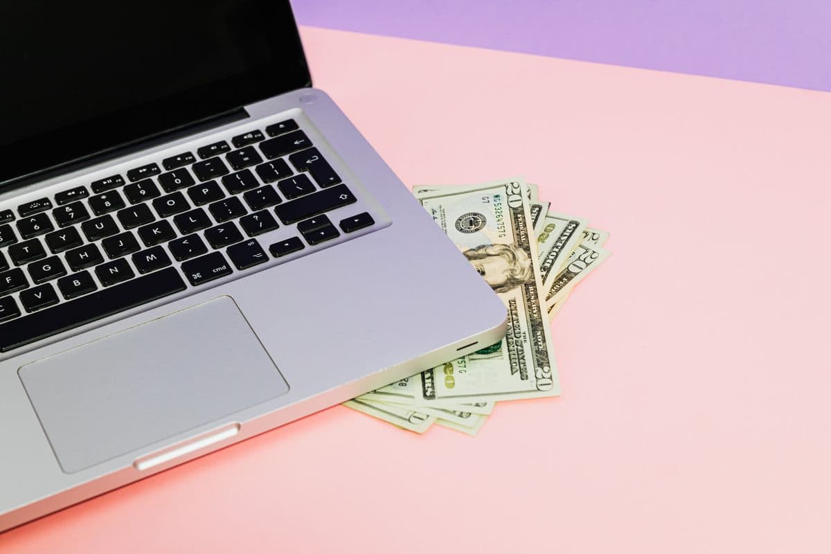 Dollar bills beside a laptop